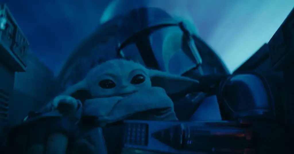 Photo still from The Mandalorian, with Mando and Grogu in the cockpit of Mando's ship.