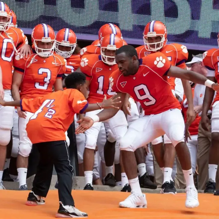Still from the movie Safety, showing a scene with Thaddeus J. Mixson as Fahmarr and Jay Reeves as Ray Ray, with additional Clemson football players in the background.