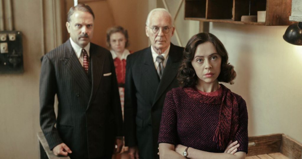 Photo still from the National Geographic show, A Small Light. From left: Nicholas Burns as Mr. Kugler, Sally Mesham as Bep, Ian McElhinney as Mr. Kleiman, and Bel Powley as Miep Gies.