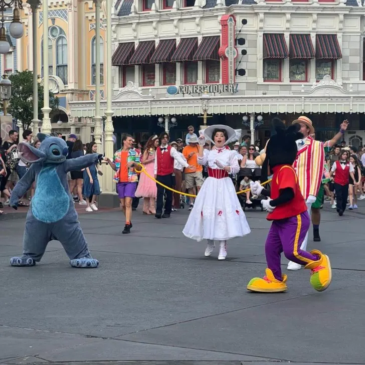 Photo of Stitch, Mary Poppins, and Max at the tail end of the Adventure Friends Calvacade down Magic Kingdom's Main Street.