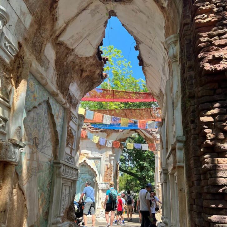 Photo of an archway in Animal Kingdom with Nepalese prayer flags in the background.