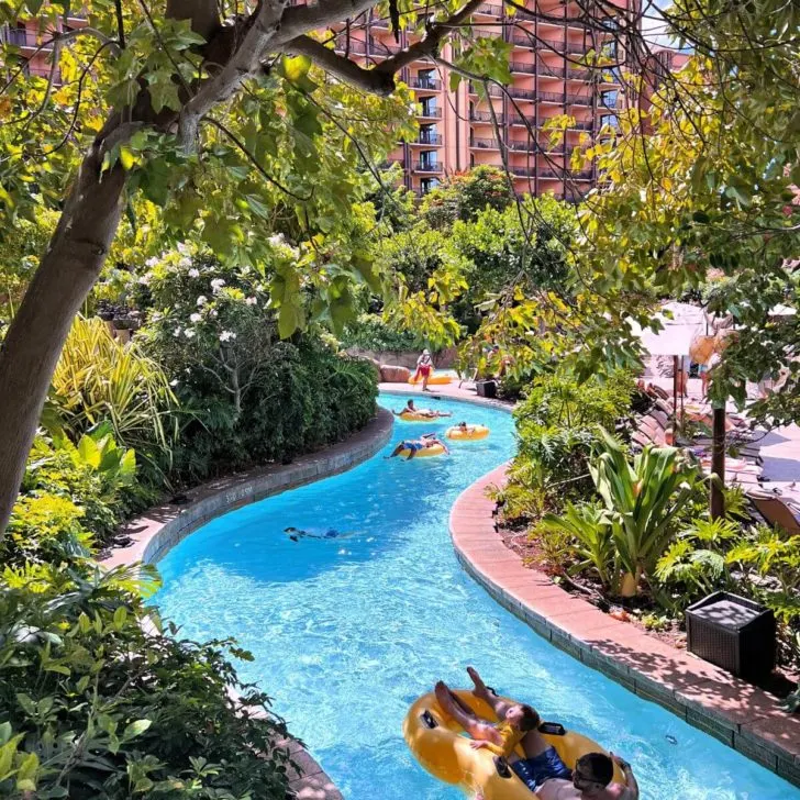 Photo of the lazy river at Aulani, with people floating by in yellow tube floats.