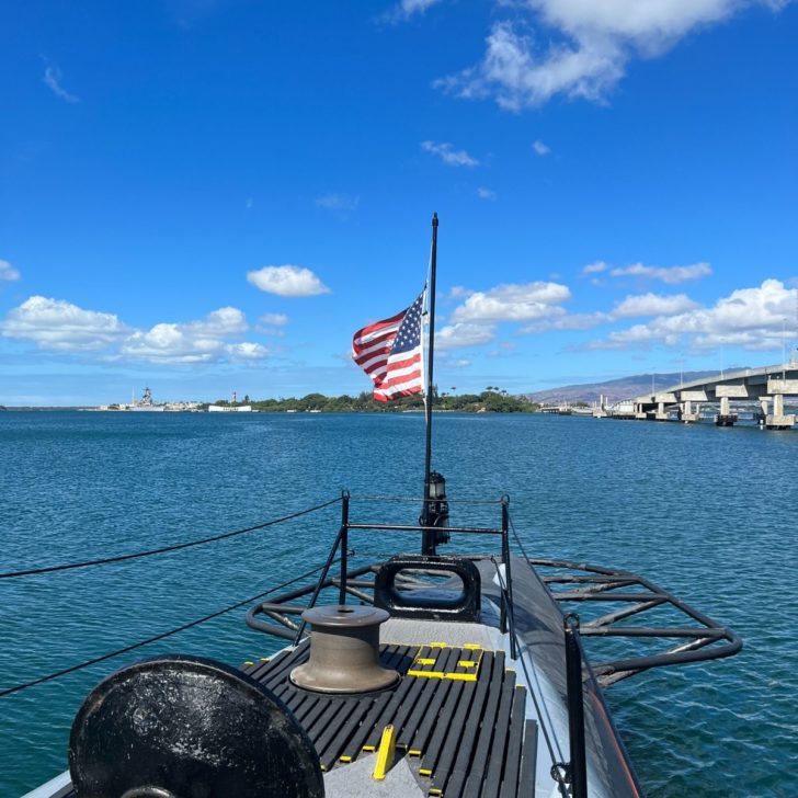 Photo from the USS Bowfin submarine at Pearl Harbor looking out the front to the ocean with an American Flag in the foreground.