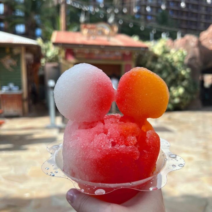 Closeup of a shave ice with red, white, and yellow colors and Mickey ears.