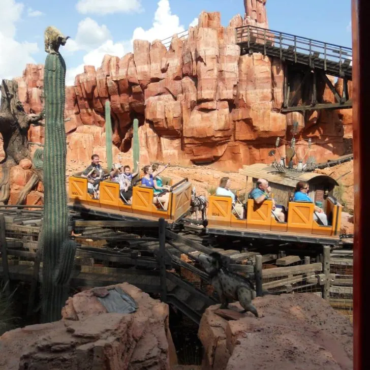 Photo of a group of people riding by on Big Thunder Mountain Railroad at Magic Kingdom.