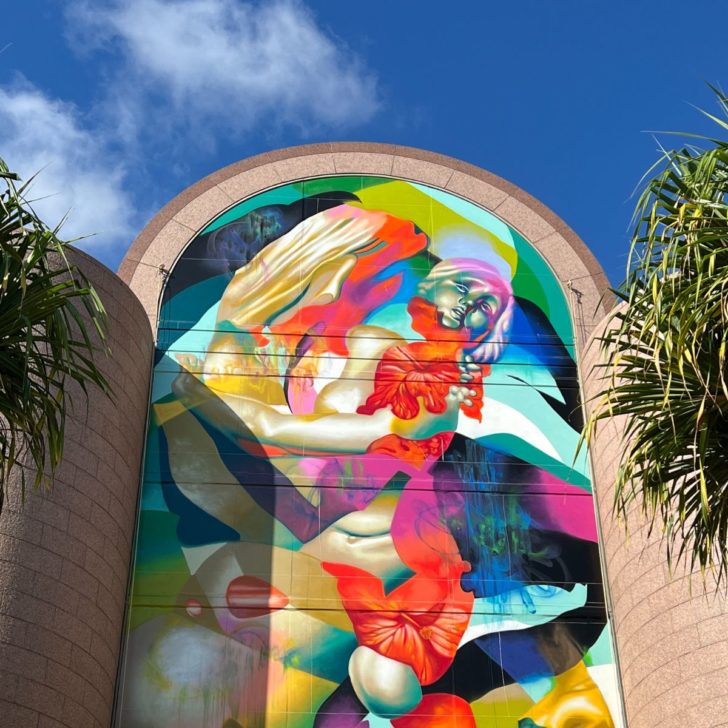 Photo of a massive, colorful street art mural at the Bishop Museum in Honolulu.