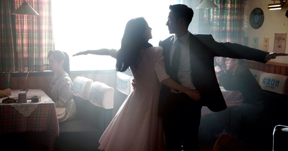 Photo still from the Disney Plus K Drama, Snowdrop, featuring a scene with Im Soo Ho (Jung Hae-In) and Eun Yeong-ro (Jisoo) dancing in a coffee shop.