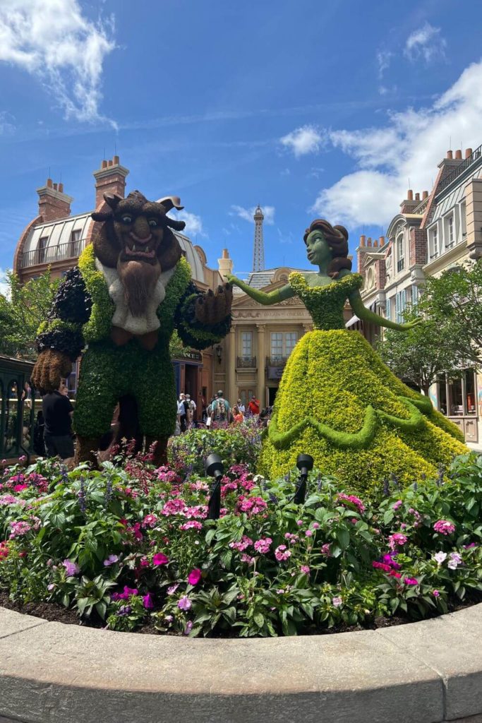 Photo of Princess Belle and Beast topiaries outside the France Pavilion in Epcot.