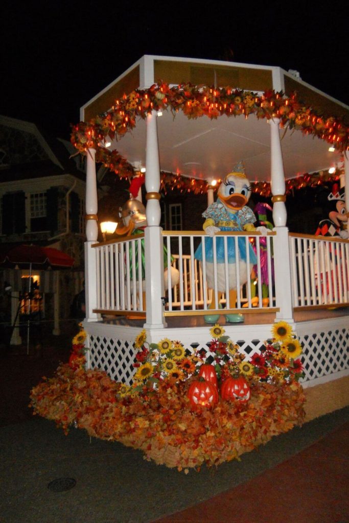 Photo of an Autumn themed gazebo shaped float with Daisy Duck and other Disney characters.