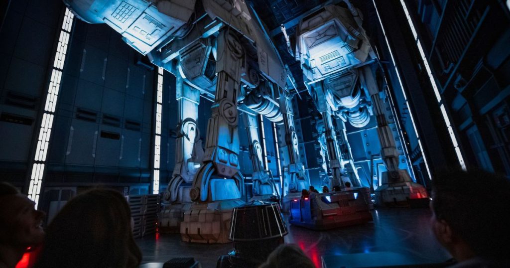 Photo of guests on ride pods maneuvering underneath giant AT-AT Walkers on Star Wars: Rise of the Resistance.