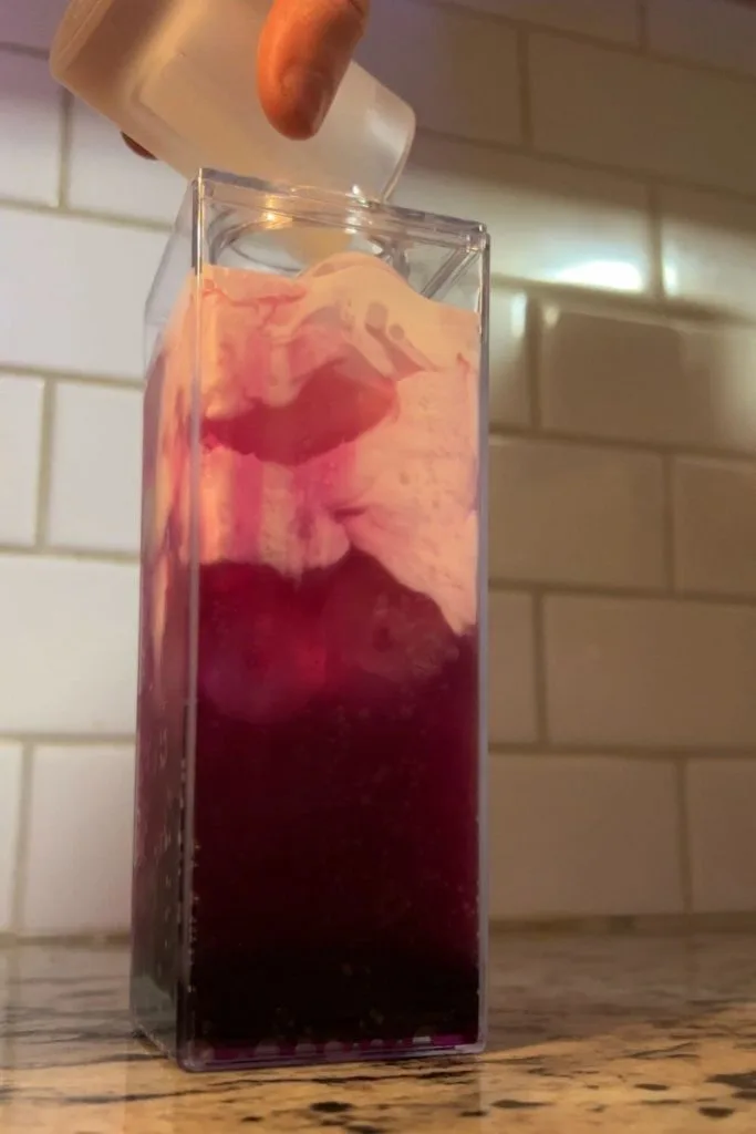 Photo of a person pouring cream over a desert pear flavored soda.