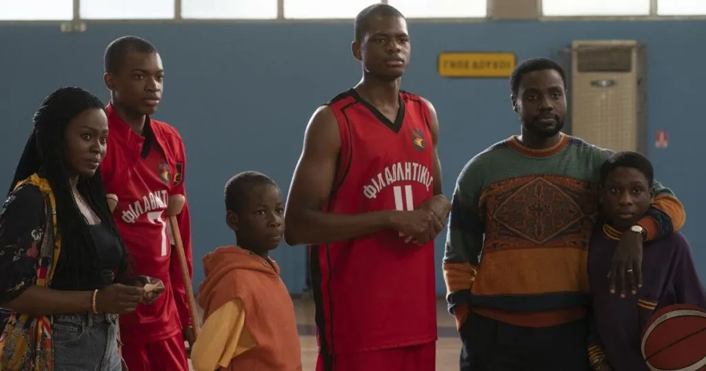 Photo still from the Disney+ movie, Rise. From left to right: Yetide Badaki as Vera, Ral Agada as Thanasis, Elijah Sholanke as Alexandros, Uche Agada as Giannis, Dayo Okeniyi as Charles, and Jaden Osimuwa as Kostas.