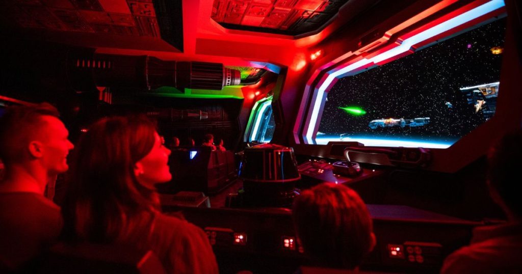 Photo of guests on Rise of the Resistance, riding by a space scene.