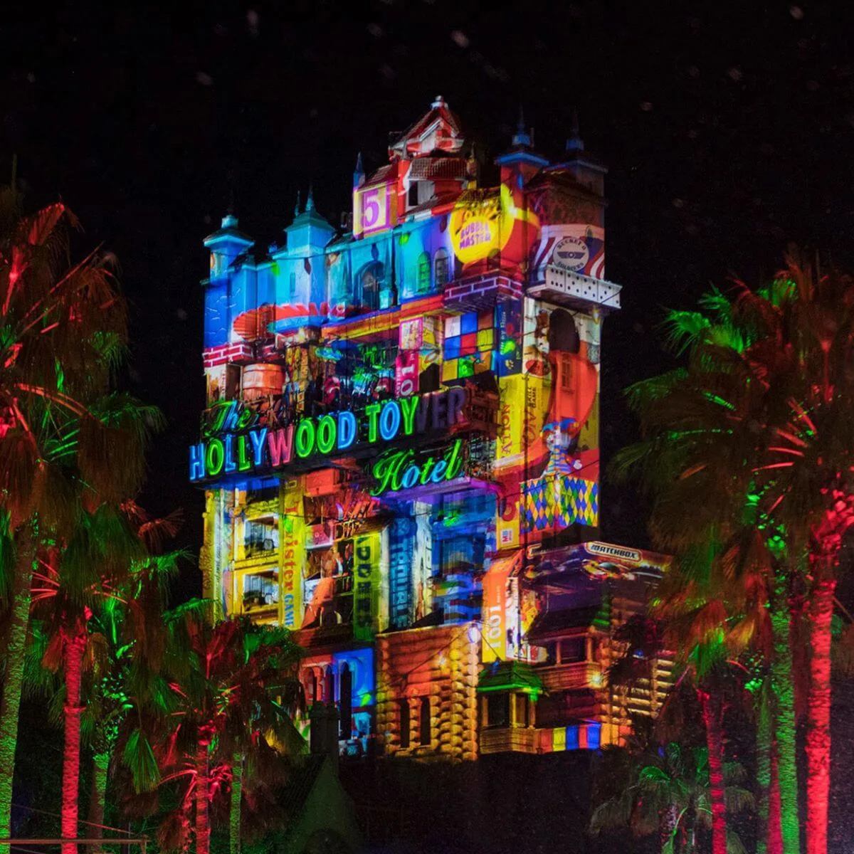 Photo of the Tower of Terror at night with Christmas themed projections on it.