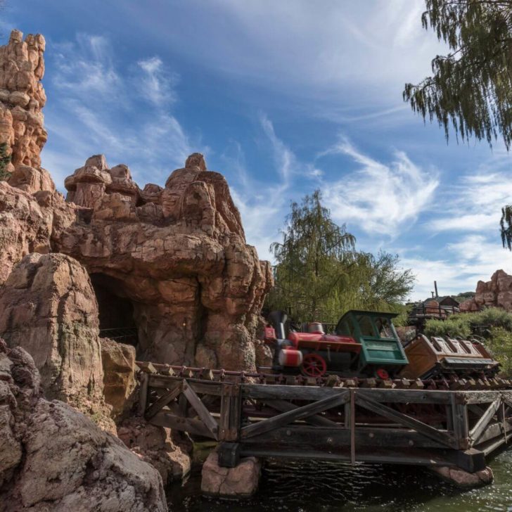 A train zips through Big Thunder Mountain and past the historic Rainbow Ridge Mining Town in Disneyland.