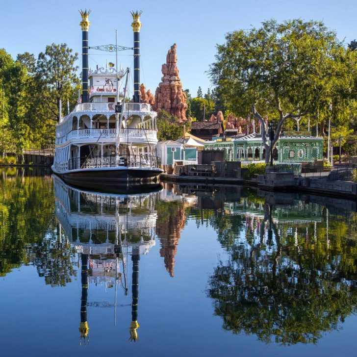 The Mark Twain Riverboat and hoodoos are reflected in the Rivers of America in Frontierland at Disneyland Park.
