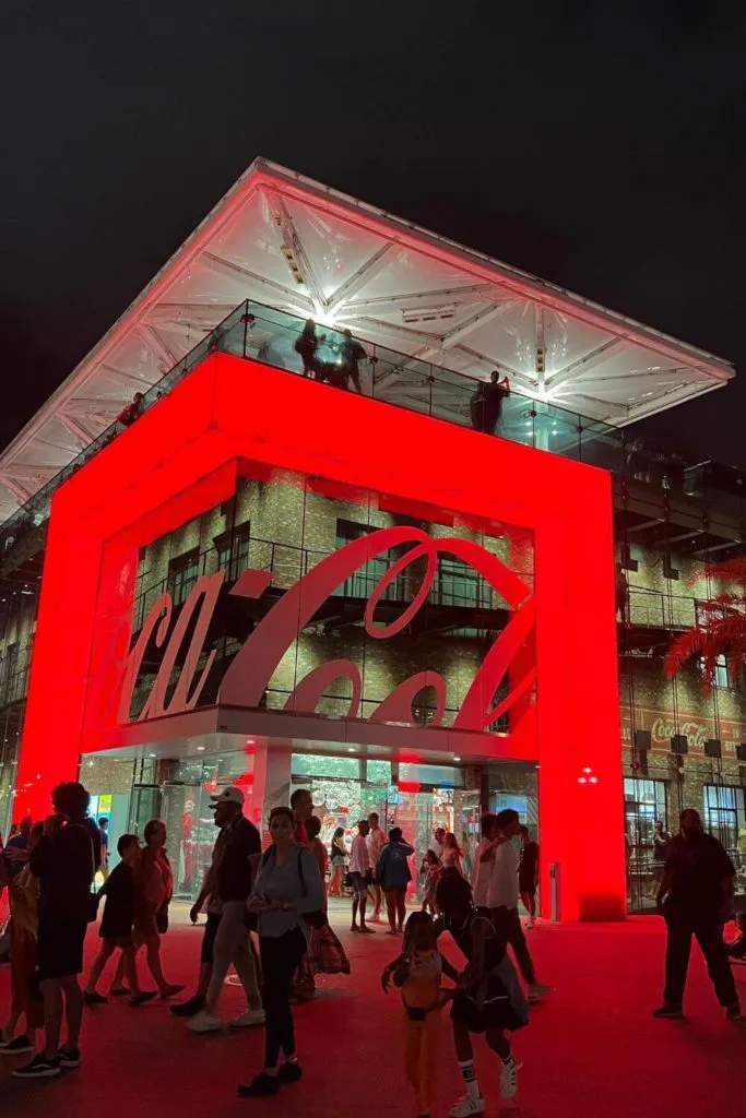 Photo of the exterior of the Coca-Cola store in Disney Springs at night.