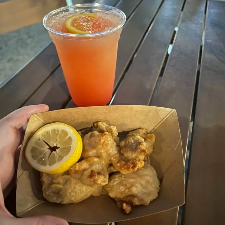 Photo of an Osaka Sunset cocktail and a tray of karaage Japanese fried chicken from Ye Sake.