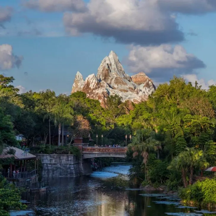 Photo of Expedition Everest from afar with a river and bridge in the forefront.