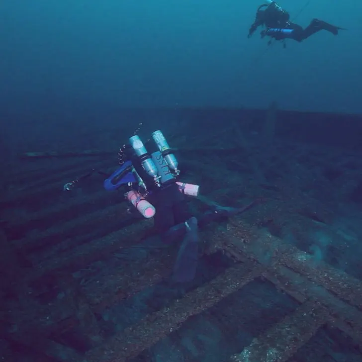 Two scuba divers exploring the Rouse Simmons shipwreck.