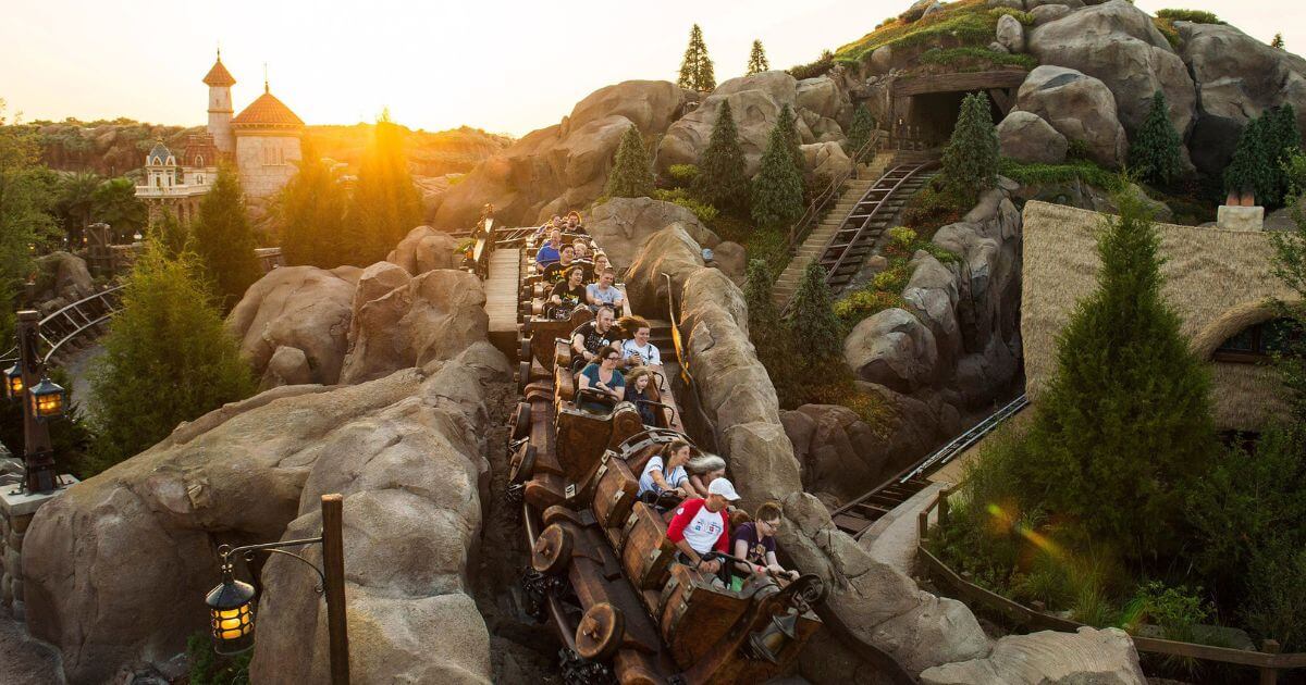 Photo of people speeding by on Seven Dwarfs Mine Train at Magic Kingdom.