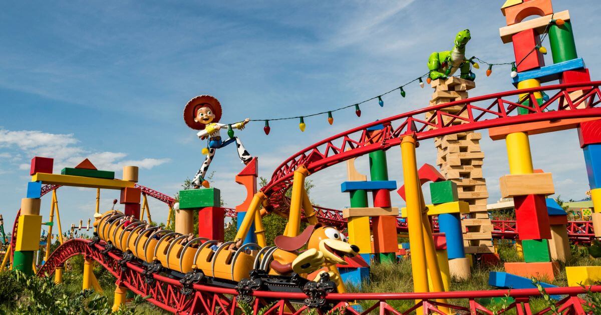 Horizontal photo of the Slinky Dog Dash roller coaster, showing the bulk of the track, with a ride car speeding by.