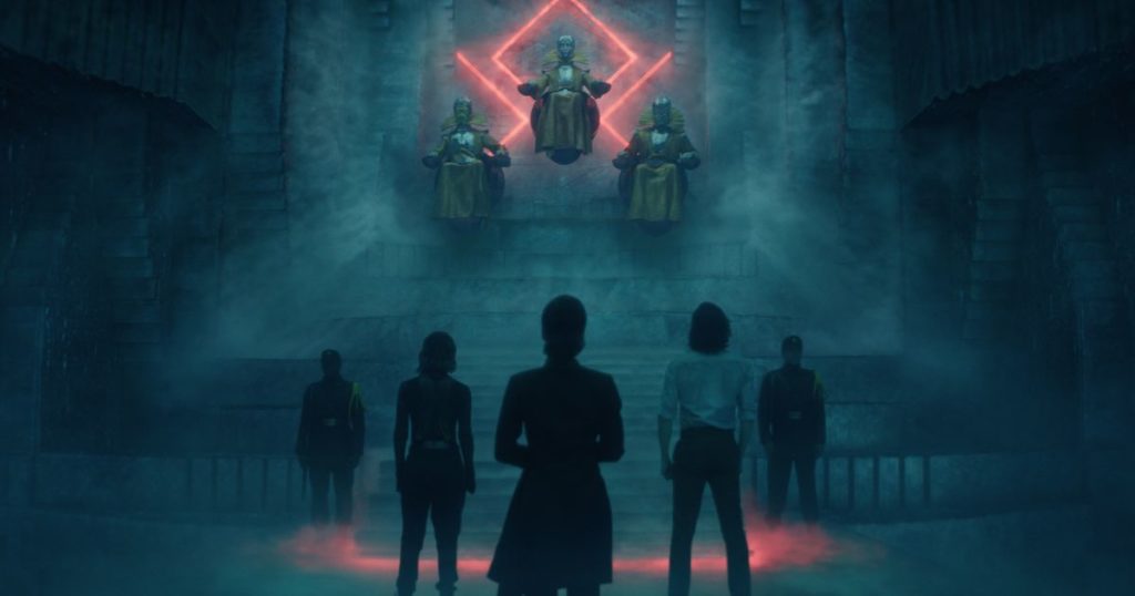 Promotional still from Loki, Season 1, Episode 4, featuring Loki (Tom Hiddleston), Sylvie (Sophia DiMartino), and Judge Renslayer (Gugu Mbatha-Raw) with their back to the camera. In the background are the 3 Timekeepers and 2 guards.