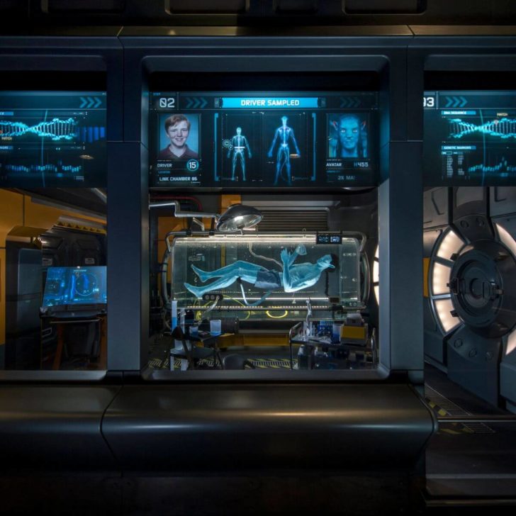 Photo of amnio tanks with avatars and screens show sample "DNA scans" as part of the ride queue for Avatar: Flight of Passage.