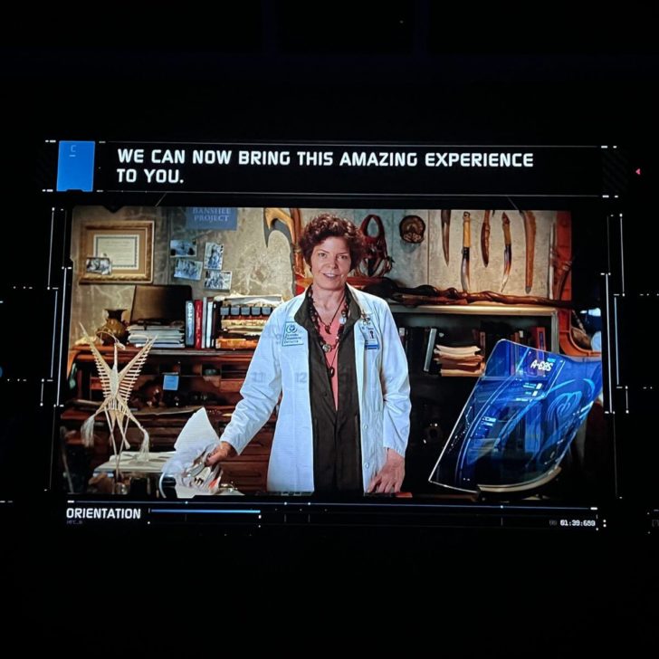 Photo from the pre-show of Flight of Passage, showing closed captioning above the video presentation.