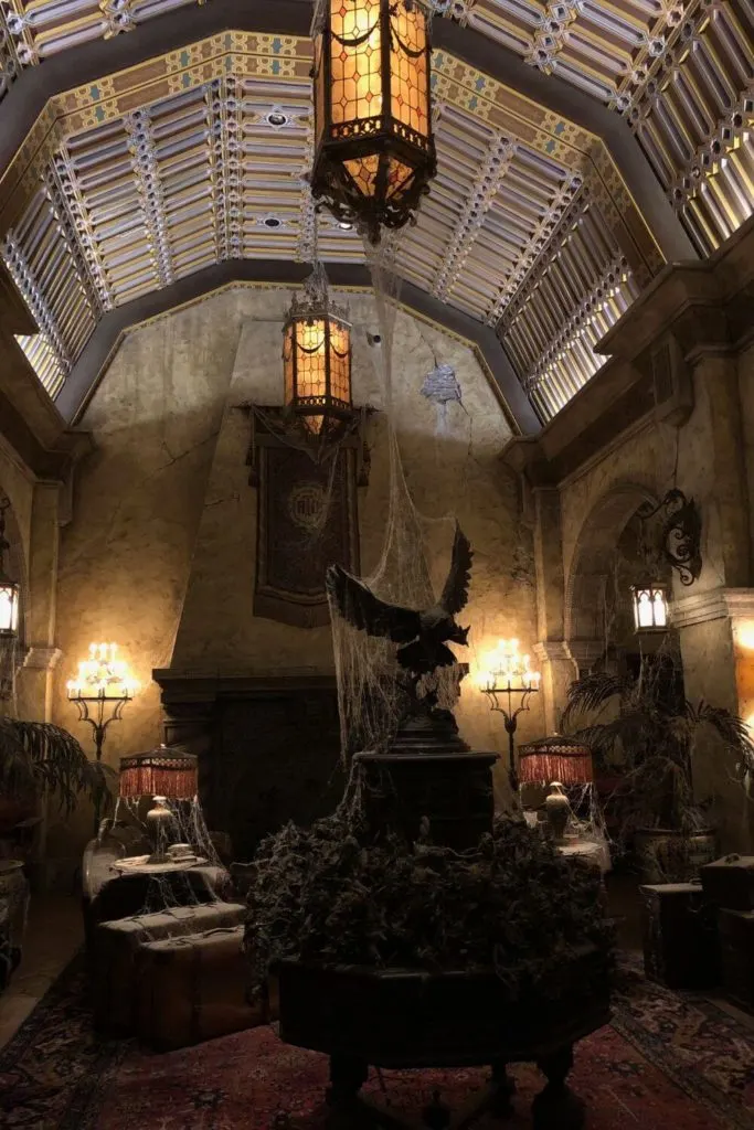 Photo of the dark and spooky interior of Tower of Terror Hollywood Studios with cobwebs, dim lighting, and Art Deco interior.
