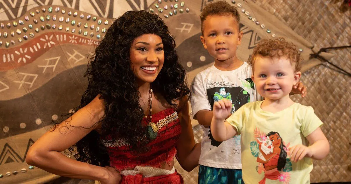 Photo of a toddler and young boy posing with Moana.
