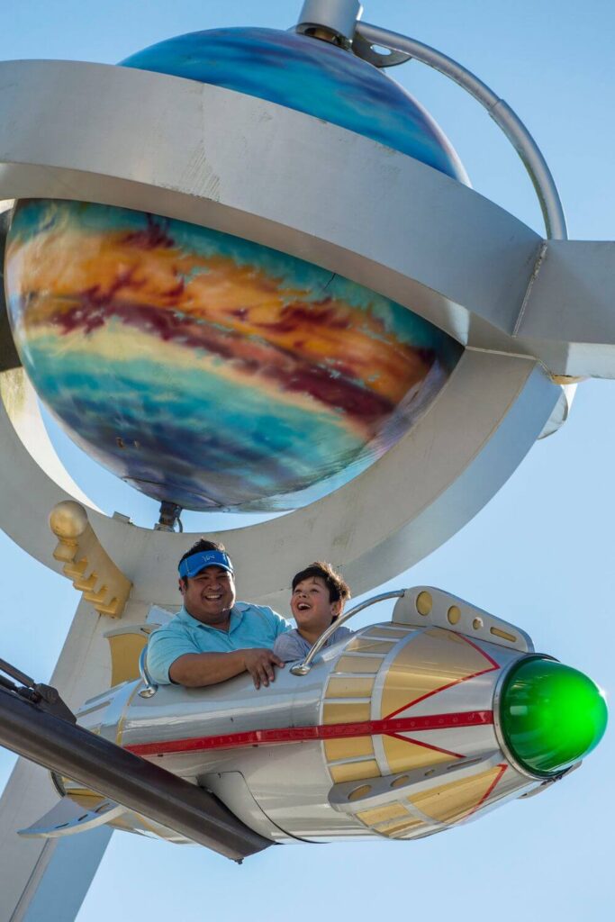 Photo of a dad and son riding the Astro Orbiter ride.