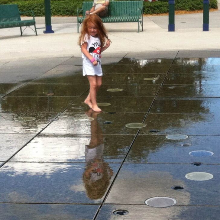 Photo of a young girl playing in a splash pad at Disney Springs.