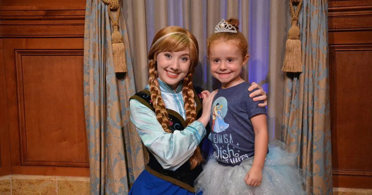 Photo of a toddler girl dressed as Cinderella posing with Anna from Frozen.