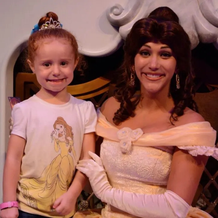 Photo of a girl wearing a Belle t-shirt while posing with Princess Belle.