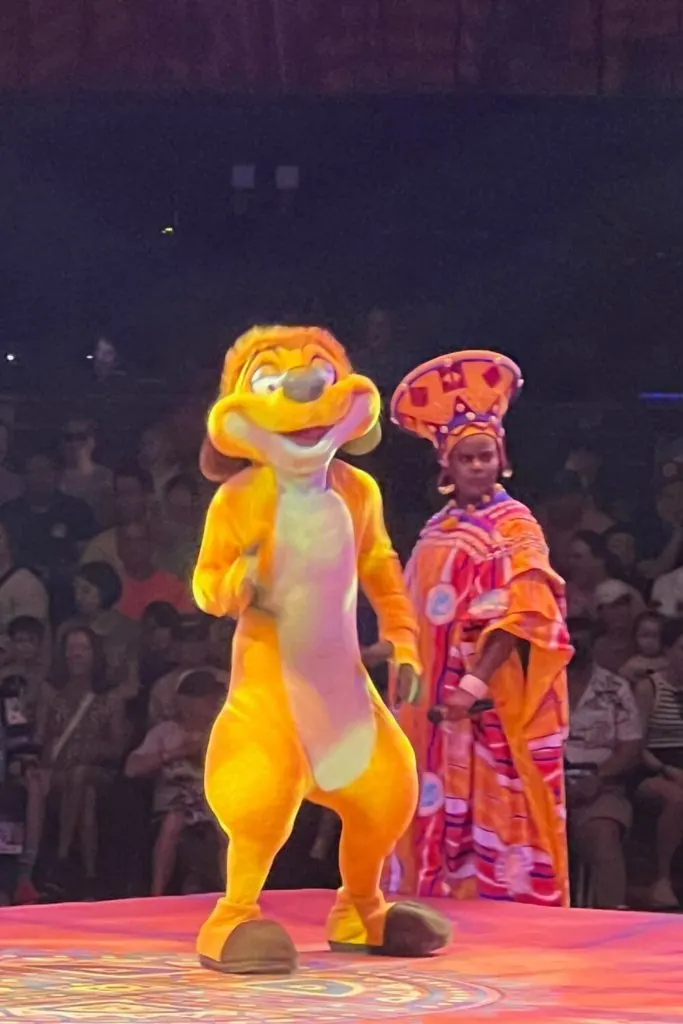 Photo of Timon and a singer at the Festival of the Lion King show.