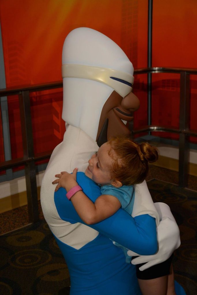 Photo of a young girl hugging Frozone at Hollywood Studios.