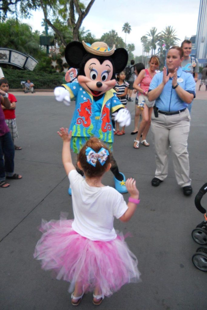 Photo of a young girl dancing with Minnie Mouse at Hollywood Studios.