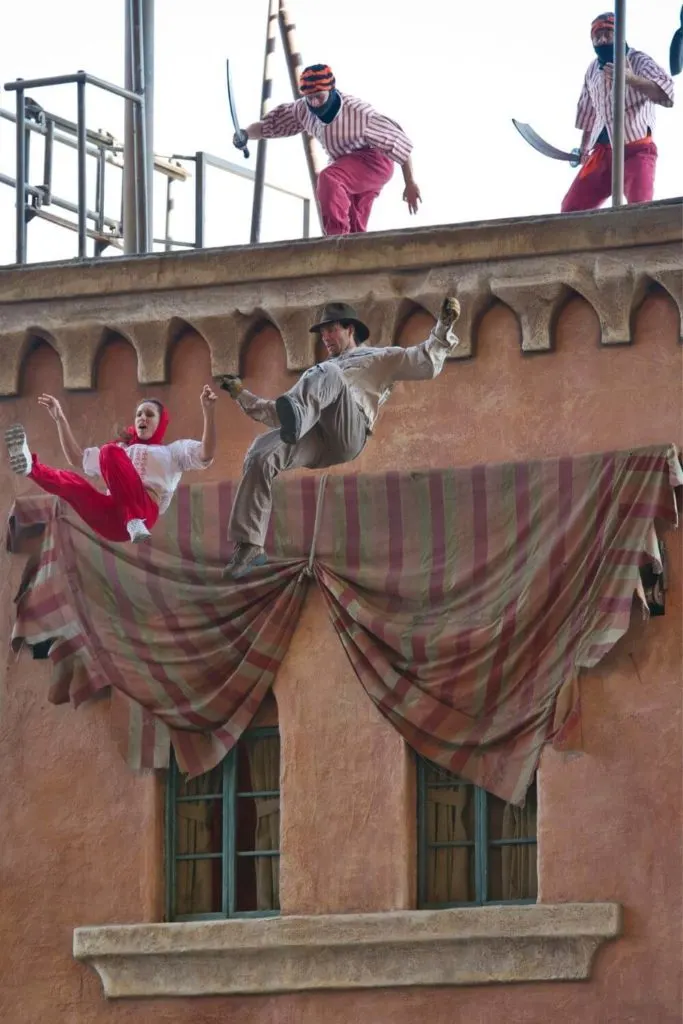 Photo of a scene from the Indiana Jones Stunt Show at Hollywood Studios with 2 actors falling from the top of a building.