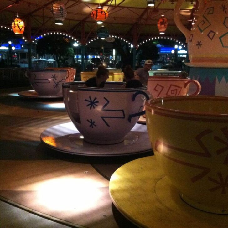 Photo of the Mad Tea Party spinning ride at night.
