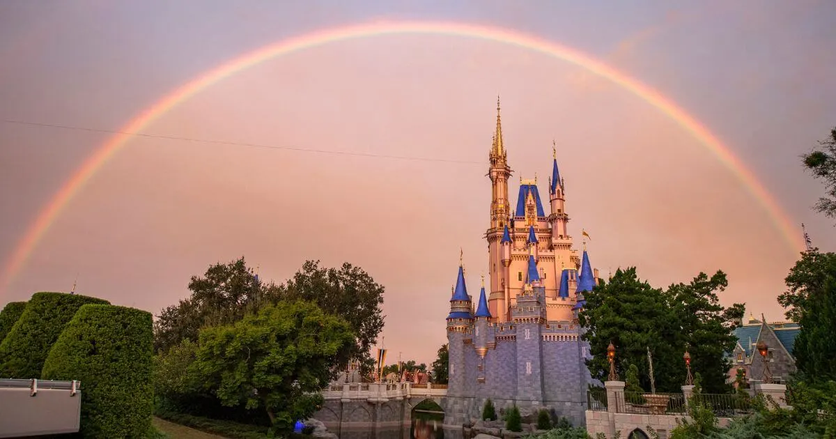Photo of Cinderella's Castle at Disney World's Magic Kingdom with a rainbow arching over it.