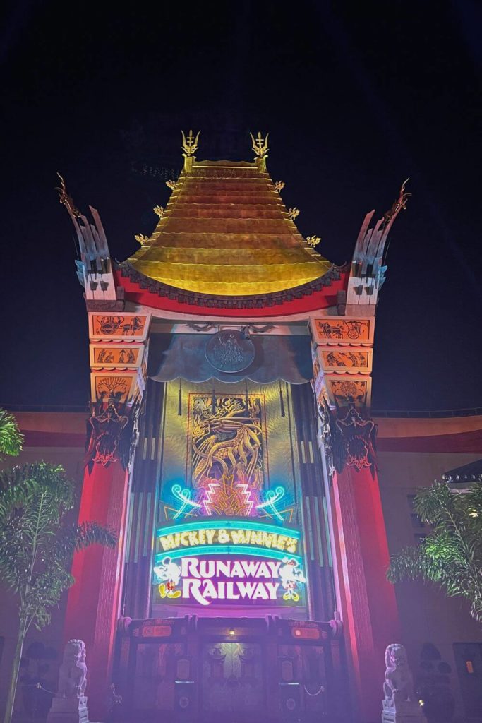 Photo of the Grauman's Chinese Theater replica with neon signage for Mickey & Minnie's Runaway Railway.