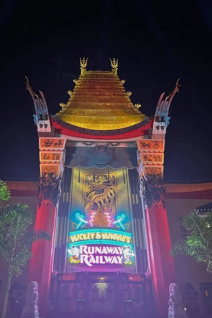 Photo of the Grauman's Chinese Theater replica with neon signage for Mickey & Minnie's Runaway Railway.