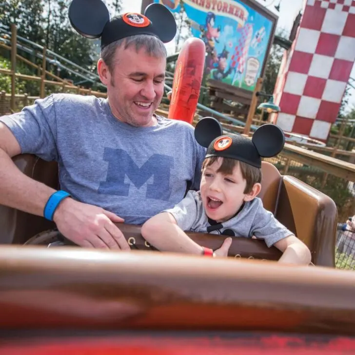 Photo of a dad and son riding The Barnstormer kiddie coaster at Magic Kingdom.