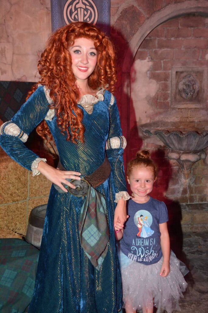 Photo of toddler girl posing with Merida at Magic Kingdom.
