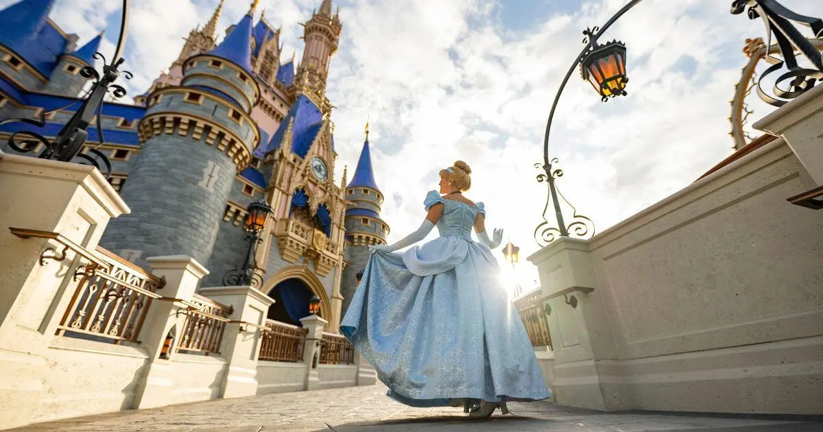 Photo of Cinderella Castle at Disney World with Cinderella walking toward it in the foreground.