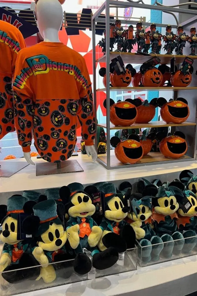 Photo of a Halloween merchandise display at Disney World, including spirit jerseys, stuffed animals, and home decor.