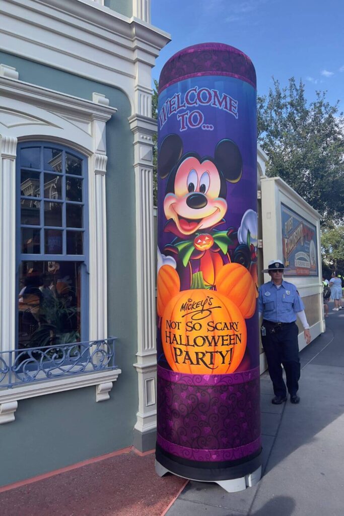 Photo of a pillar set up near the Magic Kingdom entrance with Mickey Mouse in a costume and a pumpkin that says "Mickey's Not So Scary Halloween Party."