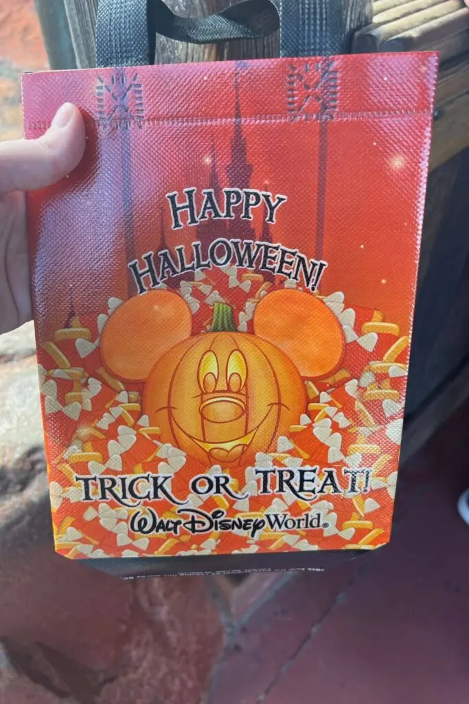 Photo of one side of the MNSSHP Trick-or-Treat Bag with a Mickey Mouse jack-o-lantern and candy corn printed on it.