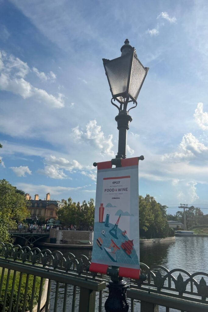 Photo of a lamp post at Epcot with a Epcot Food & Wine Festival banner.